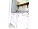This bright laundry room features a modern washer and dryer and a floating shelf at 5203 Oak Charter Ct # 5203, Temple Terrace, FL 33617