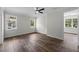 Bright bedroom with hardwood floors, a ceiling fan, and windows overlooking the surrounding neighborhood at 5701 N 20Th St, Tampa, FL 33610