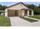 Front exterior view of a home with a spacious driveway and manicured lawn at 5701 N 20Th St, Tampa, FL 33610