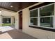 Covered porch entry featuring brick detail around the windows, a dark red front door, and concrete flooring at 5701 N 20Th St, Tampa, FL 33610