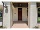 Covered front porch featuring brick columns, a ceiling light, and a dark red front door with house number at 5701 N 20Th St, Tampa, FL 33610