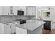 Well-lit kitchen featuring white cabinets, gray countertops, stainless steel appliances, and stylish backsplash at 5701 N 20Th St, Tampa, FL 33610