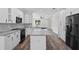Open-concept kitchen with quartz countertops, black stainless steel appliances, and hardwood floors at 5701 N 20Th St, Tampa, FL 33610