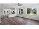 Bright, open living room with hardwood floors and large windows showcasing the landscaped yard at 5701 N 20Th St, Tampa, FL 33610