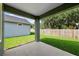 Covered back porch with stained concrete flooring, green beams, and view of backyard and fence at 5703 N 20Th St, Tampa, FL 33610