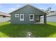 Exterior back of home with a covered porch and a green grass backyard at 5703 N 20Th St, Tampa, FL 33610