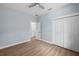 Bedroom with light blue walls, wood-look vinyl flooring, a ceiling fan, and closet at 5703 N 20Th St, Tampa, FL 33610