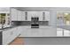 Modern kitchen featuring gray backsplash, stainless appliances, and large center island at 5703 N 20Th St, Tampa, FL 33610