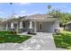 Charming light gray home featuring a covered porch with sturdy pillars and a spacious driveway at 5705 N 20Th St, Tampa, FL 33610