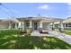 Charming light gray home featuring a covered porch with sturdy pillars and a spacious driveway at 5705 N 20Th St, Tampa, FL 33610