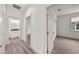 Bright hallway featuring wood-look flooring, white trim, and access to a bathroom and bedroom at 5705 N 20Th St, Tampa, FL 33610