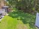 Large backyard with lush green grass, shade trees, screened in porch, and white picket fence at 6234 Ashbury Palms Dr, Tampa, FL 33647