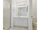 Clean bathroom with a glass-enclosed shower, white tile flooring, and vanity with a large mirror at 6234 Ashbury Palms Dr, Tampa, FL 33647