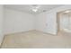 Well-lit bedroom features white walls, neutral carpet, ceiling fan, and access to other rooms at 6234 Ashbury Palms Dr, Tampa, FL 33647