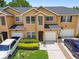 Inviting townhome showcases a well-maintained lawn, charming yellow and white facade, and private driveways at 6234 Ashbury Palms Dr, Tampa, FL 33647