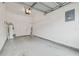 Clean and bright garage, featuring painted walls, concrete floors, and shelving for storage at 6234 Ashbury Palms Dr, Tampa, FL 33647