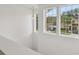 Upstairs hallway featuring windows overlooking the street, neutral paint, and a pendant light at 6234 Ashbury Palms Dr, Tampa, FL 33647