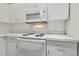 White kitchen featuring white cabinets, countertops, and appliances, including a microwave and range at 6234 Ashbury Palms Dr, Tampa, FL 33647