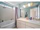 Bright bathroom with a tub-shower combination, neutral walls, and a vanity with ample counter space at 7534 Oxford Garden Cir, Apollo Beach, FL 33572