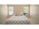 Bright bedroom featuring tile flooring, a bed with decorative pillows, and natural light through two windows at 7534 Oxford Garden Cir, Apollo Beach, FL 33572