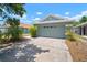 Suburban home with a two-car garage, a concrete driveway, and landscaping beneath a partly cloudy sky at 7534 Oxford Garden Cir, Apollo Beach, FL 33572