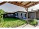 View of the backyard with green grass, and the house's exterior, taken from under a covered patio at 8330 Lafitte Dr, Hudson, FL 34667