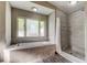 Bright bathroom with soaking tub under window and tiled shower with glass door at 8330 Lafitte Dr, Hudson, FL 34667