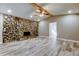 Spacious living room features stone fireplace, ceiling fan, and wood-look flooring at 8330 Lafitte Dr, Hudson, FL 34667