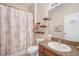 Bathroom with a shower-tub combo, wooden shelves, and wooden cabinets under a single sink at 8518 Tidal Breeze Dr, Riverview, FL 33569