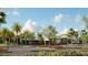 The modern clubhouse is set among lush landscaping, palm trees, and well maintained parking areas at 8747 Flourish Dr, Land O Lakes, FL 34637