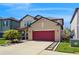Two story home with a red garage door, well maintained lawn, and a landscaped walkway at 8747 Flourish Dr, Land O Lakes, FL 34637