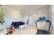 Bright and airy flex room featuring a sofa, treadmill, and access to staircase with natural light at 8747 Flourish Dr, Land O Lakes, FL 34637