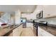 Well-equipped kitchen with stainless steel appliances, granite countertops, ample cabinet space, and staircase nearby at 8747 Flourish Dr, Land O Lakes, FL 34637