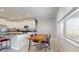 Bright kitchen with granite countertops, stainless steel appliances, an island with seating, and a dining area near a sunny window at 8747 Flourish Dr, Land O Lakes, FL 34637