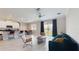 Bright living room with tile floors, modern furnishings, open to the kitchen with views of the backyard and a nearby lake at 8747 Flourish Dr, Land O Lakes, FL 34637