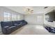 Spacious living room featuring a wall of windows, plush seating, and a ceiling fan at 8747 Flourish Dr, Land O Lakes, FL 34637