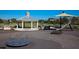 Community playground area with a gazebo and shade structure, surrounded by green space, and some playground equipment at 8747 Flourish Dr, Land O Lakes, FL 34637