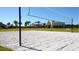 Outdoor sand volleyball court in a grassy area with community buildings and palm trees in the background at 8747 Flourish Dr, Land O Lakes, FL 34637
