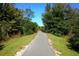 Scenic walking path through lush foliage featuring a wooden bridge crossing, under a clear blue sky at 8747 Flourish Dr, Land O Lakes, FL 34637