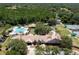 Overhead view of the community center with a pool, tennis court, clubhouse, and playground amid green landscapes at 9116 Woodridge Run Dr, Tampa, FL 33647