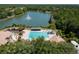 Picturesque aerial view of the community's pool, recreation area, and lake against a backdrop of lush forests at 9116 Woodridge Run Dr, Tampa, FL 33647