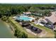 High-angle view of the community's pool, playground, and recreation areas complemented by lush greenery and a lake at 9116 Woodridge Run Dr, Tampa, FL 33647