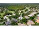 Aerial view of home featuring tile roof, screened pool, located near a golf course and pond at 9116 Woodridge Run Dr, Tampa, FL 33647