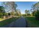 Paved community path in a park-like setting with mature trees, benches, and lush grass at 9116 Woodridge Run Dr, Tampa, FL 33647