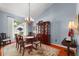 Elegant dining room with hardwood floors, classic chandelier, and a large window with natural light at 9116 Woodridge Run Dr, Tampa, FL 33647
