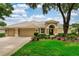 Charming home with a well-maintained lawn, a tan color scheme, and a beautiful tile roof at 9116 Woodridge Run Dr, Tampa, FL 33647