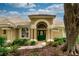 Inviting entryway with a green front door, landscaped garden, and a charming arched entrance at 9116 Woodridge Run Dr, Tampa, FL 33647