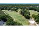 Aerial view showing a section of golf course with pristine green fairways, bunkers, and mature trees at 9116 Woodridge Run Dr, Tampa, FL 33647