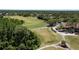 Aerial view of the golf course driving range, surrounded by lush greenery and golf carts at 9116 Woodridge Run Dr, Tampa, FL 33647