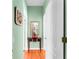 Charming hallway with hardwood floors, decorative mirror, and table creating an inviting passage at 9116 Woodridge Run Dr, Tampa, FL 33647